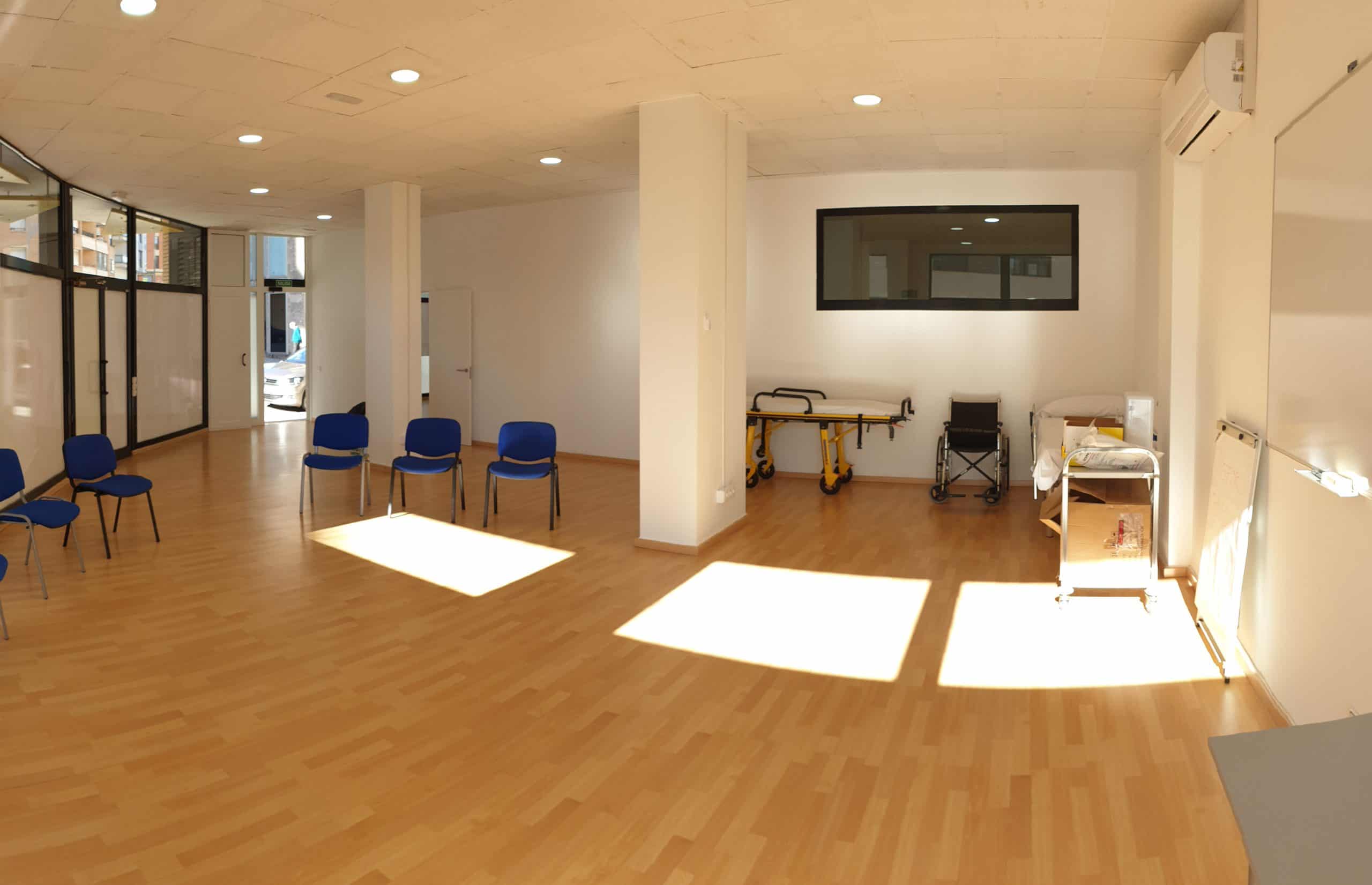 Una habitació buida amb cadires i una finestra.