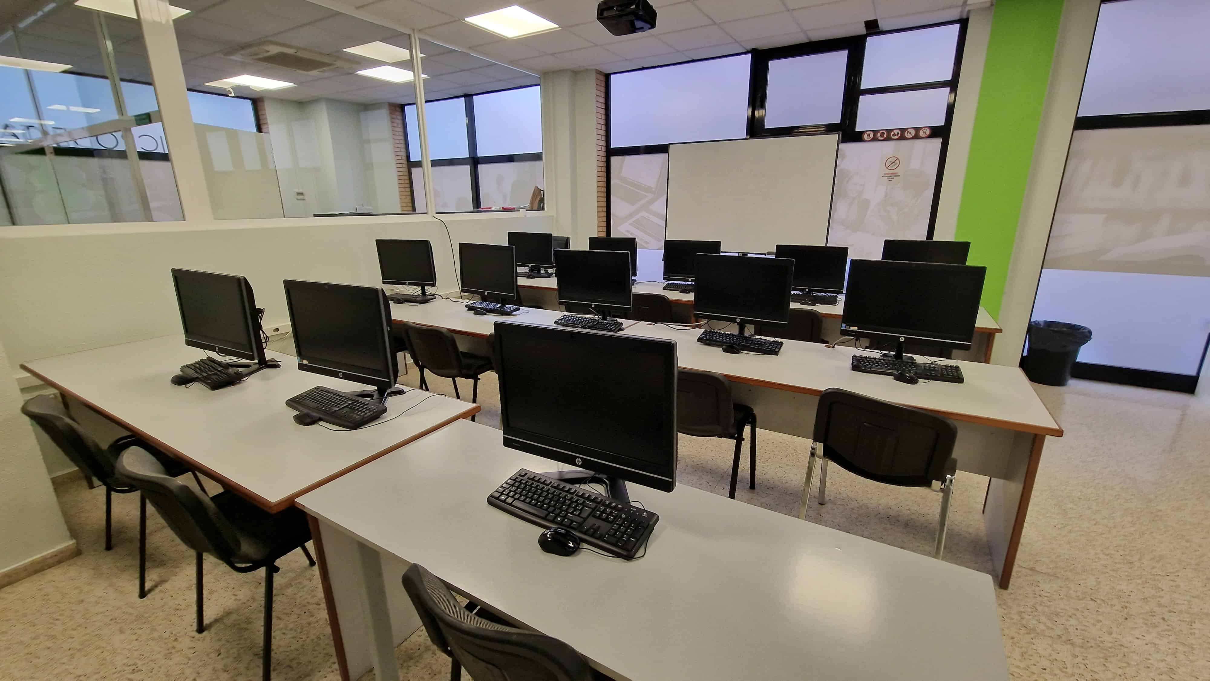 Una aula amb diversos ordinadors i monitors.